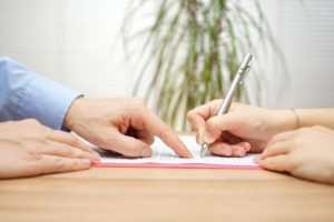client signing paperwork with a lawyer
