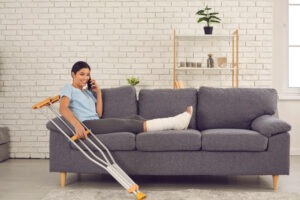 woman on couch with crutches