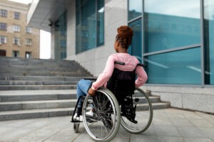 black woman in wheelchair approaching stairs