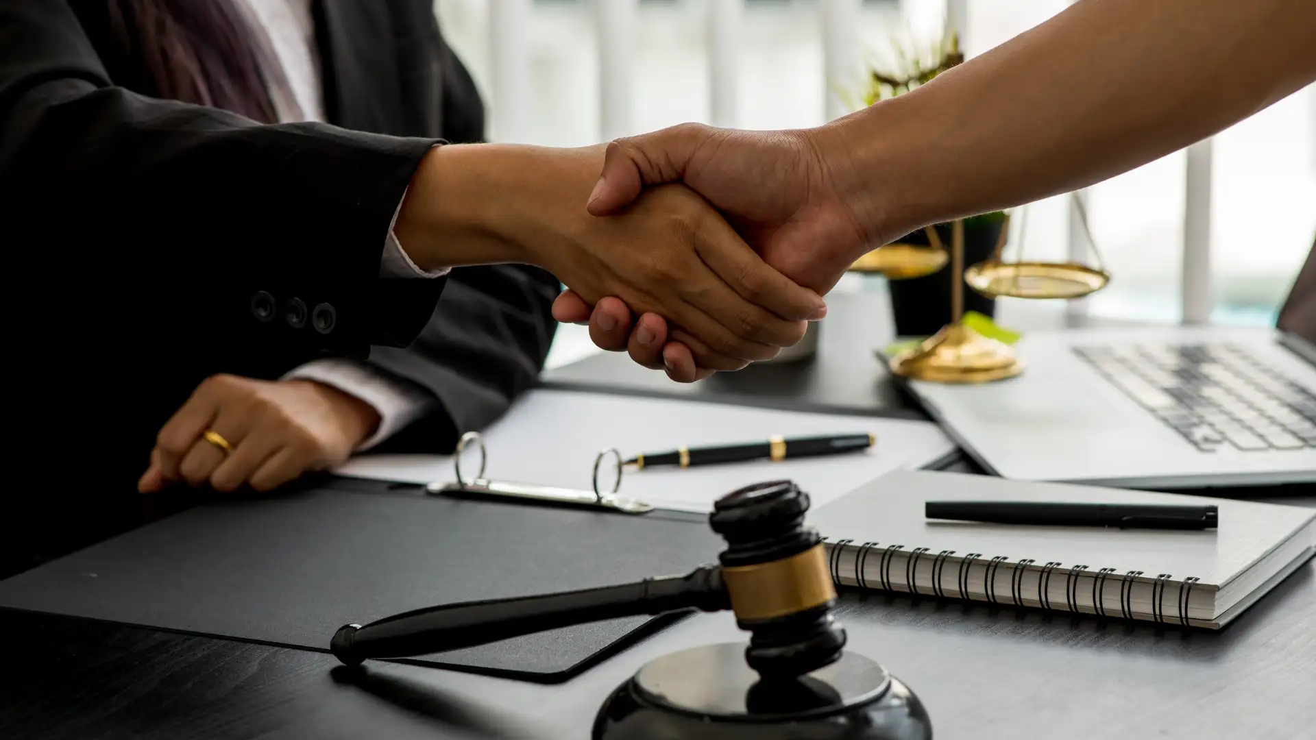 Handshake in a legal setting, symbolizing agreement or settlement.