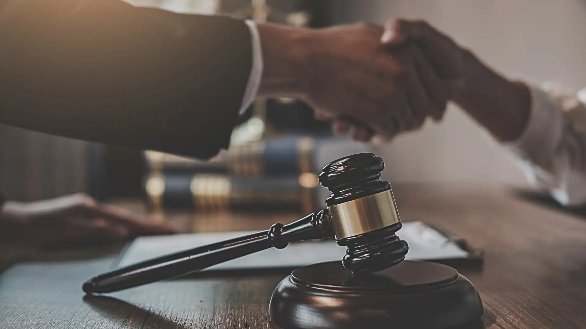 Legal agreement or settlement with a handshake and gavel.