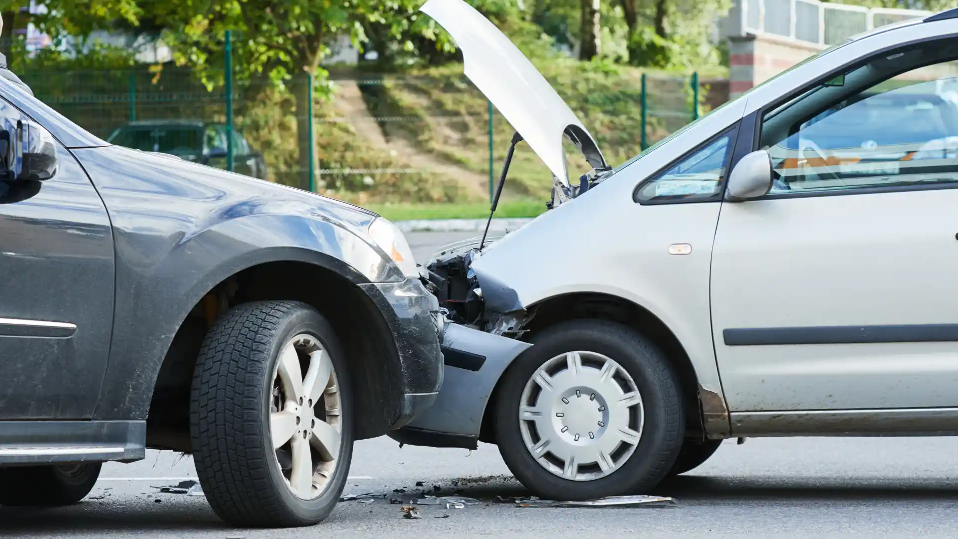 Two cars involved in a front-end collision with damage to the bumpers.