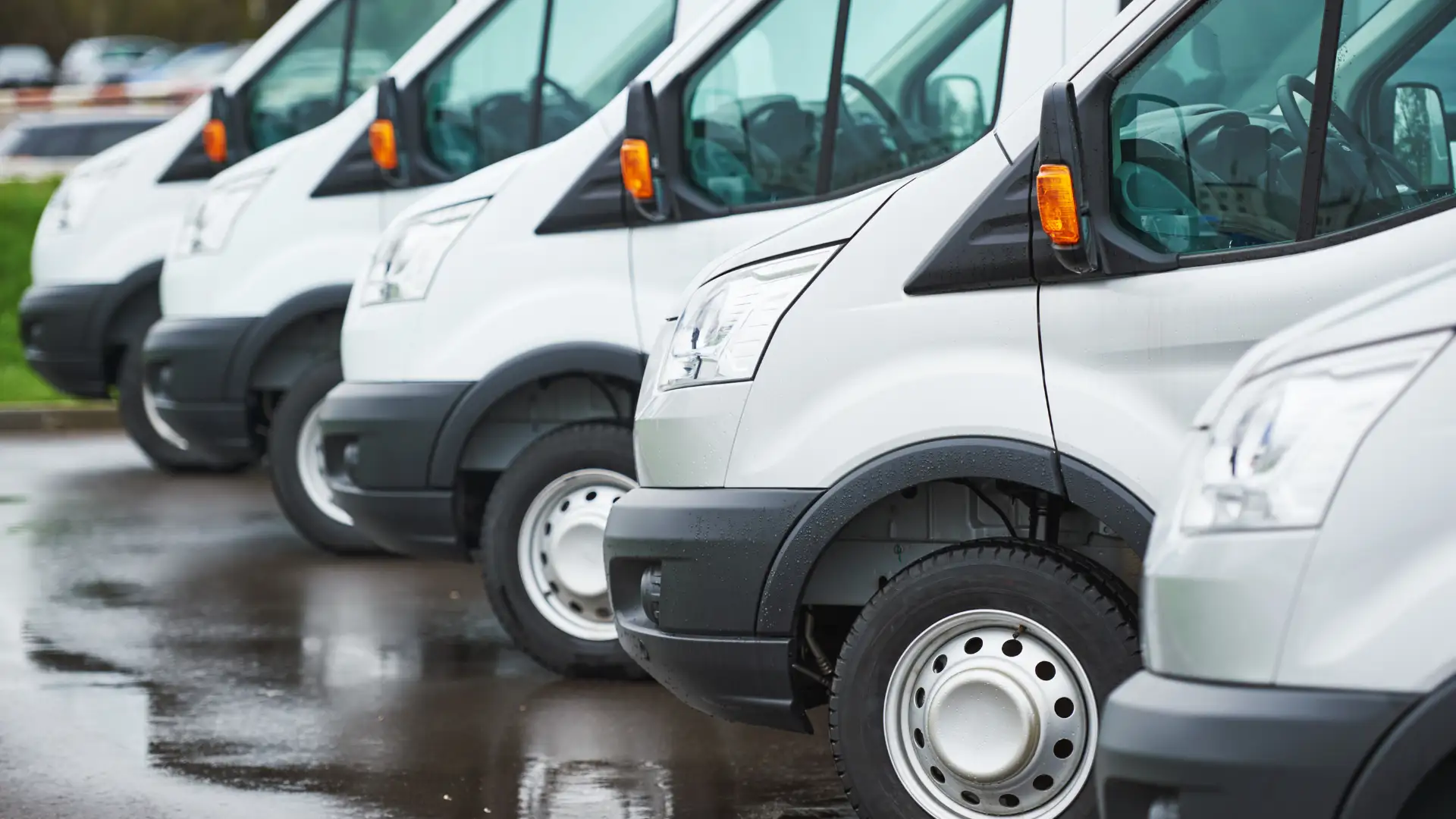 Row of parked delivery vans with a focus on the front section.